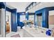 Bright bathroom featuring a long vanity, bright blue walls, crystal light fixture, and tile flooring at 218 Brandywine Circle, Englewood, FL 34223