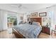Bedroom with a wood bed frame and sliding door access to an outdoor living space at 218 Brandywine Circle, Englewood, FL 34223