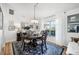 Dining area featuring an elegant chandelier, dark wood table, and decorative window treatments at 218 Brandywine Circle, Englewood, FL 34223