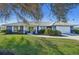 Charming single-story home with a well-manicured lawn, blue exterior, and bright green double-door entrance at 218 Brandywine Circle, Englewood, FL 34223