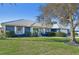 Charming single-story home featuring a beautiful lawn, white-framed windows, and a vibrant blue exterior paint at 218 Brandywine Circle, Englewood, FL 34223