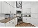 Bright kitchen showcasing stainless steel appliances, granite countertops, and white cabinetry at 218 Brandywine Circle, Englewood, FL 34223