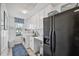 Functional laundry room with washer, dryer, ample storage, and a modern black refrigerator at 218 Brandywine Circle, Englewood, FL 34223