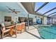 Covered outdoor patio featuring a dining area, comfortable seating, and a view of the sparkling pool at 218 Brandywine Circle, Englewood, FL 34223