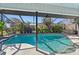 Inviting screened-in pool featuring a hot tub and tropical landscaping, perfect for outdoor enjoyment at 218 Brandywine Circle, Englewood, FL 34223