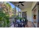 Screened porch with table and chairs and lush tropical plants at 294 Hidden Bay Dr # 103, Osprey, FL 34229