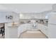 Modern white kitchen with granite countertops and stainless steel appliances at 9397 Midnight Pass Rd # 505, Sarasota, FL 34242