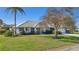 Single-story home with a blue exterior, white garage door, and lush landscaping at 218 Brandywine Circle, Englewood, FL 34223