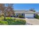 Charming single story home with a blue exterior, white garage door, and manicured lawn at 218 Brandywine Circle, Englewood, FL 34223