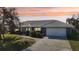Ranch style home with a blue exterior, white garage door and walkway at 218 Brandywine Circle, Englewood, FL 34223