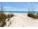 Beach access through a pathway lined with lush sea grass at 5941 Gulf Of Mexico Dr, Longboat Key, FL 34228