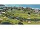 Aerial view of a lush golf course with water features and oceanfront homes at 5941 Gulf Of Mexico Dr, Longboat Key, FL 34228