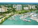 Aerial view of a vibrant marina with numerous boats and waterfront buildings at 5941 Gulf Of Mexico Dr, Longboat Key, FL 34228