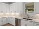 Modern kitchen with white cabinets, geometric tile backsplash and stainless steel sink at 17113 Malta Ave, Port Charlotte, FL 33954