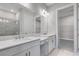Bathroom with double sink vanity, walk-in shower, and closet entrance at 10442 Morning Mist, Sarasota, FL 34241