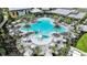 Aerial view of a large community pool featuring lounge chairs, umbrellas, and a water slide at 10442 Morning Mist, Sarasota, FL 34241