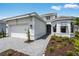 New construction single Gathering home featuring a gray brick driveway and manicured landscaping at 10442 Morning Mist, Sarasota, FL 34241