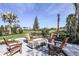 Outdoor fire pit with Adirondack chairs, offering a cozy gathering spot in a landscaped setting at 10442 Morning Mist, Sarasota, FL 34241