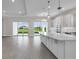 Open concept kitchen with an island and white cabinets, offering a seamless flow to the living area at 10442 Morning Mist, Sarasota, FL 34241