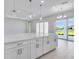 Bright kitchen featuring white cabinets, an island with quartz countertops, and stainless steel appliances at 10442 Morning Mist, Sarasota, FL 34241