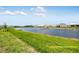 Backyard pond view with green lawn and new construction single Gathering homes at 10442 Morning Mist, Sarasota, FL 34241