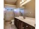 Bathroom includes a shower, toilet and vanity with dark wood cabinets at 22575 Morning Glory Cir, Bradenton, FL 34202