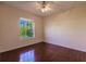 Simple bedroom with hardwood floors and a window overlooking the backyard at 22575 Morning Glory Cir, Bradenton, FL 34202