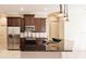 Modern kitchen with dark wood cabinets, granite countertops, and stainless steel appliances at 22575 Morning Glory Cir, Bradenton, FL 34202