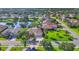 Aerial view of a home with well-manicured lawns, a pond, and mature trees in a residential neighborhood at 2921 Seasons Blvd, Sarasota, FL 34240