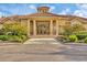 Exterior shot displays the clubhouse with a tile roof, manicured landscaping, and covered entry at 2921 Seasons Blvd, Sarasota, FL 34240