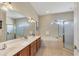 Well-appointed main bathroom featuring a double vanity, a soaking tub, and a separate glass-enclosed shower at 2921 Seasons Blvd, Sarasota, FL 34240