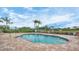 Community pool with brick pavers, clear blue water, palm trees, and plenty of space for relaxation at 2921 Seasons Blvd, Sarasota, FL 34240