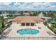 Aerial view features a community pool with ample seating, surrounded by palm trees and lush landscaping at 2921 Seasons Blvd, Sarasota, FL 34240