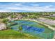 Aerial view of well-maintained tennis courts surrounded by lush landscaping and palm trees for active community engagement at 2921 Seasons Blvd, Sarasota, FL 34240