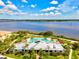 Aerial view of a waterfront community clubhouse with a swimming pool and lush landscaping at 5130 Tidewater Preserve Blvd, Bradenton, FL 34208