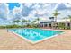 Beautiful community pool with clear blue water surrounded by palm trees and lounge chairs at 5130 Tidewater Preserve Blvd, Bradenton, FL 34208