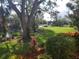 Landscaped yard with a pond, lush greenery, and a wooden bench at 6466 Seagull Dr # 323, Bradenton, FL 34210