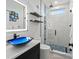 This bathroom features a glass shower with blue accents, an illuminated mirror, and a blue glass vessel sink at 6741 Rookery Lake Dr, Bradenton, FL 34212