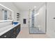 Modern bathroom with glass shower featuring blue tile accents, and black vanity with blue glass sink at 6741 Rookery Lake Dr, Bradenton, FL 34212