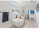 Bathroom with soaking tub, and black fixtures, and floating shelves at 6741 Rookery Lake Dr, Bradenton, FL 34212