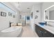 Bathroom featuring large tub, walk-in shower, and black vanity with a blue glass sink at 6741 Rookery Lake Dr, Bradenton, FL 34212