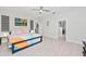 Bright bedroom with ceiling fan, light colored wood floors, and doors to closet space at 6741 Rookery Lake Dr, Bradenton, FL 34212