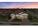 Beautiful home with a colorful sunset backdrop, double garage, and meticulously landscaped front yard at 6741 Rookery Lake Dr, Bradenton, FL 34212