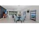 Open concept dining room with glass table and blue chairs, view of living room and pool at 6741 Rookery Lake Dr, Bradenton, FL 34212