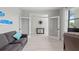 A cozy living room featuring a gray sofa, accent pillows, and an open doorway to the office at 6741 Rookery Lake Dr, Bradenton, FL 34212