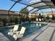 Inviting screened pool area featuring in-pool seating, lush landscaping, and ample space for entertaining at 6741 Rookery Lake Dr, Bradenton, FL 34212
