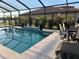 Relaxing screened-in pool with a tile waterfall feature and outdoor seating at 6741 Rookery Lake Dr, Bradenton, FL 34212
