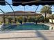 Inviting screened-in pool area with blue tile and lush landscaping at 6741 Rookery Lake Dr, Bradenton, FL 34212