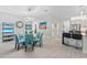 Stylish dining room with glass top table, blue chairs, and kitchen view at 6741 Rookery Lake Dr, Bradenton, FL 34212