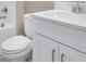 Bathroom featuring white cabinet and toilet with matching white bathtub and shower in the background at 7661 Moonbeam Ave, Sarasota, FL 34241